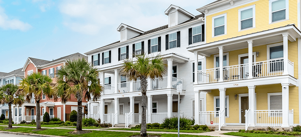 Villas on the Strand townhomes with palm trees in front of them