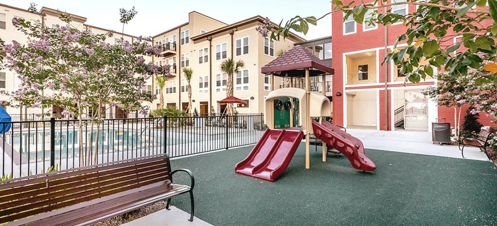 Villas on the Strand playground with benches and a pool