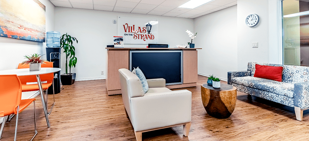 Villas on the Strand leasing Office with a tv and a table and chairs