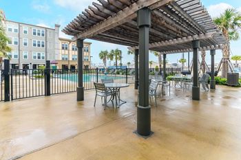 The sun deck with seating near the swimming pool at Villas on the Strand apartments in Galveston, TX