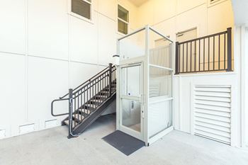 the stairwell of a building with a glass elevator door at Villas on the Strand apartments in Galveston, TX