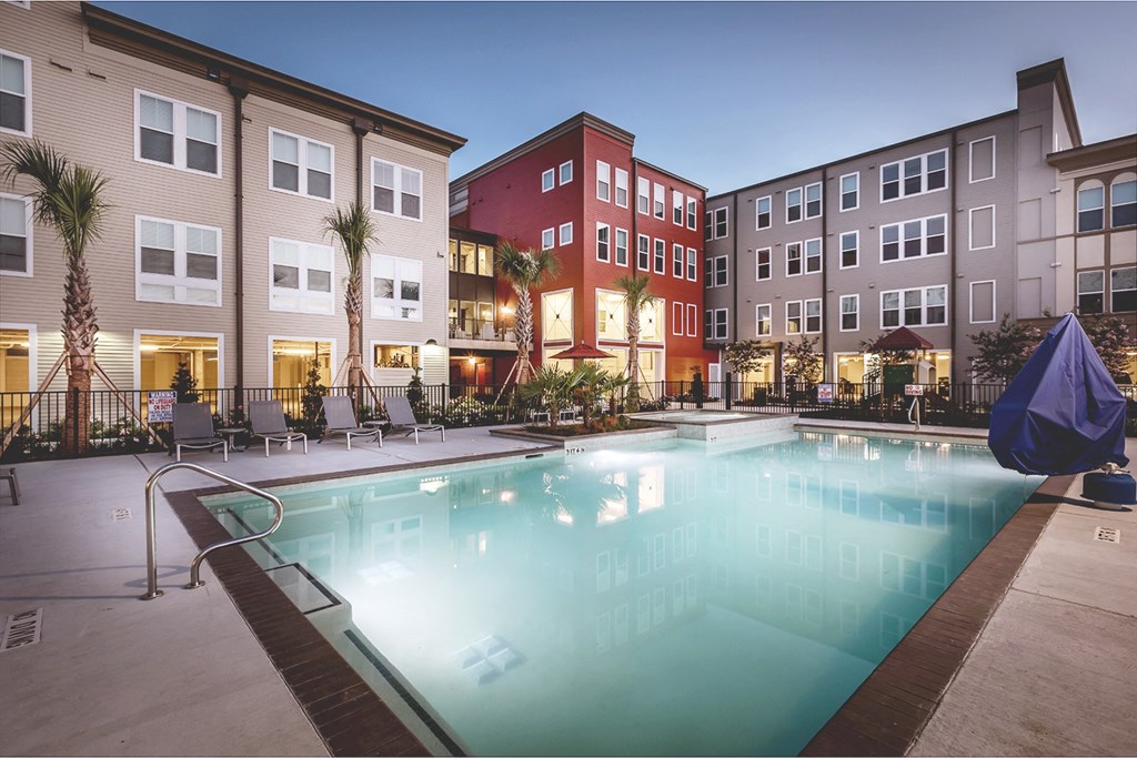 a swimming pool in front of a row of apartment buildings