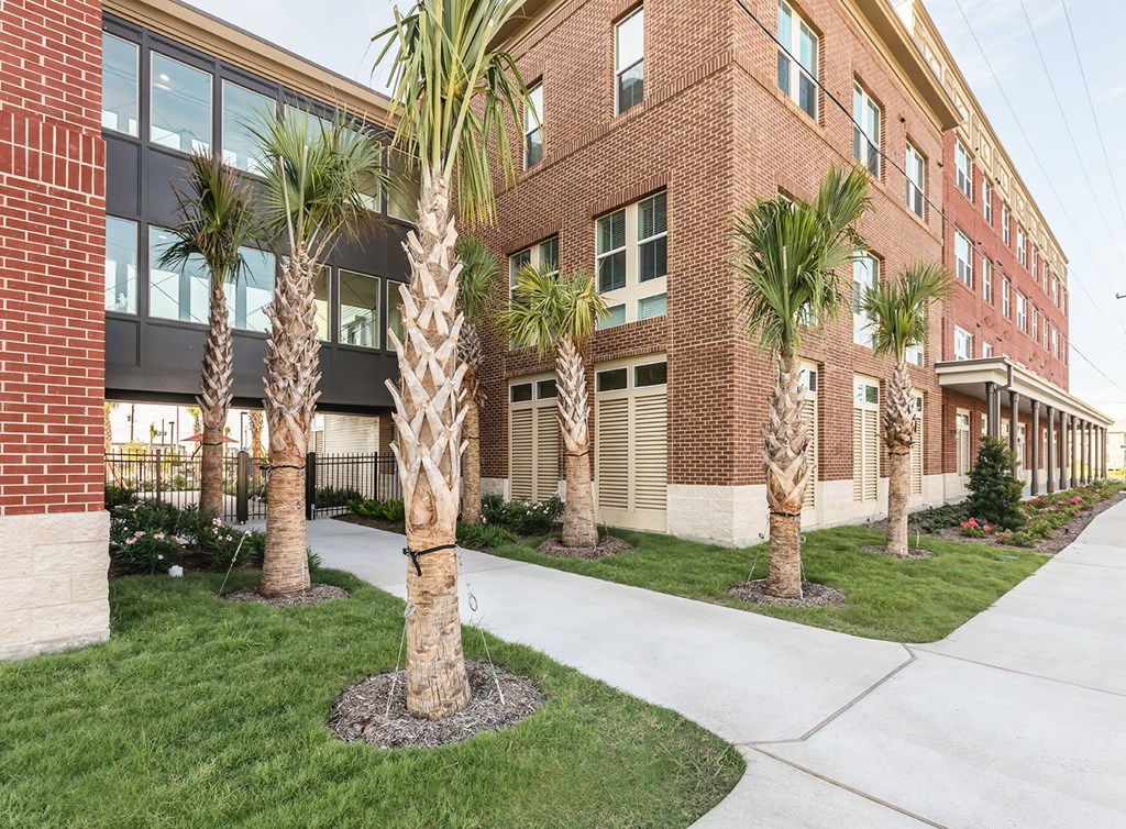 a brick building with palm trees in front of it