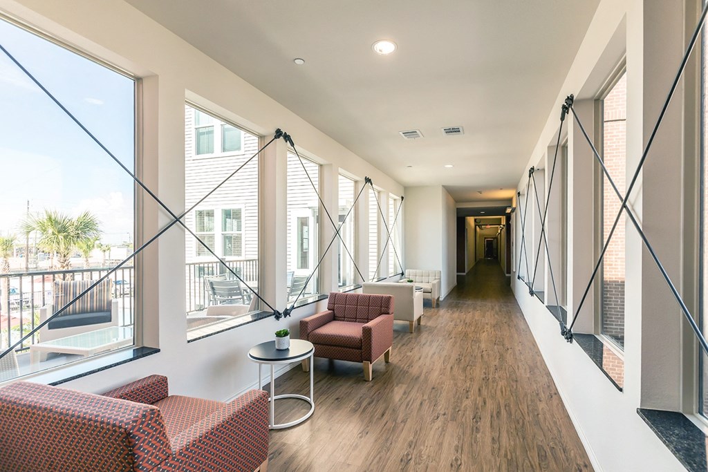 a long hallway with couches and chairs and large windows
