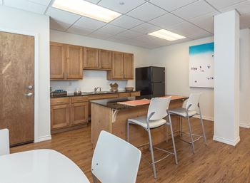 a kitchen with a table and chairs and a refrigerator at Villas on the Strand apartments in Galveston, TX