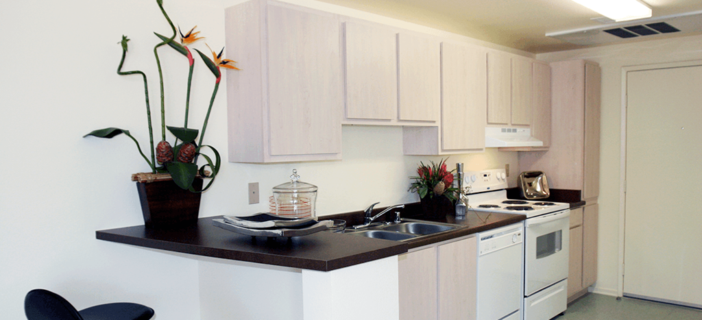 a kitchen with white appliances and white cabinets at Vista Sunrise Apartments