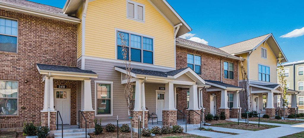 a row of townhouses with brick and yellow and brown roofs