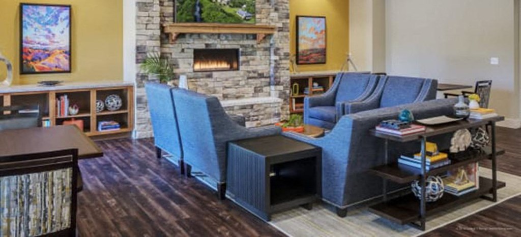 a living room with blue chairs and a fireplace