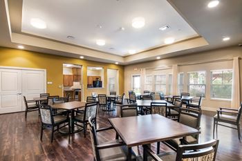 a dining room with tables and chairs and a kitchen