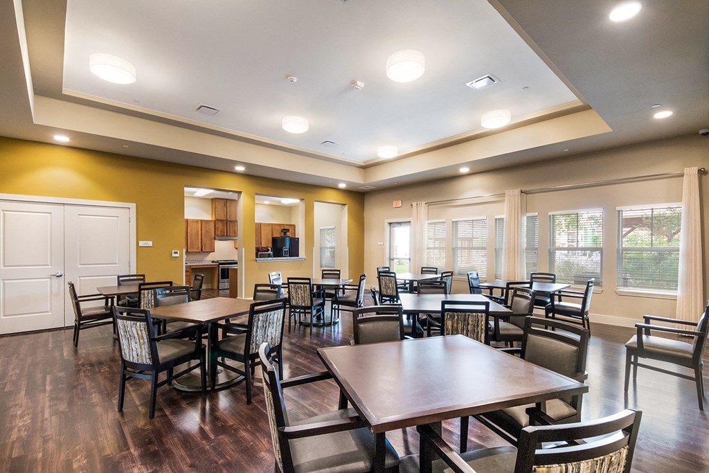 a dining room with tables and chairs and a kitchen