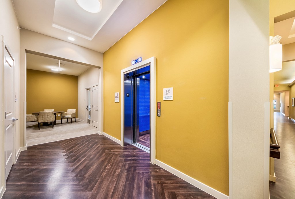 a hallway with a yellow wall and a blue door