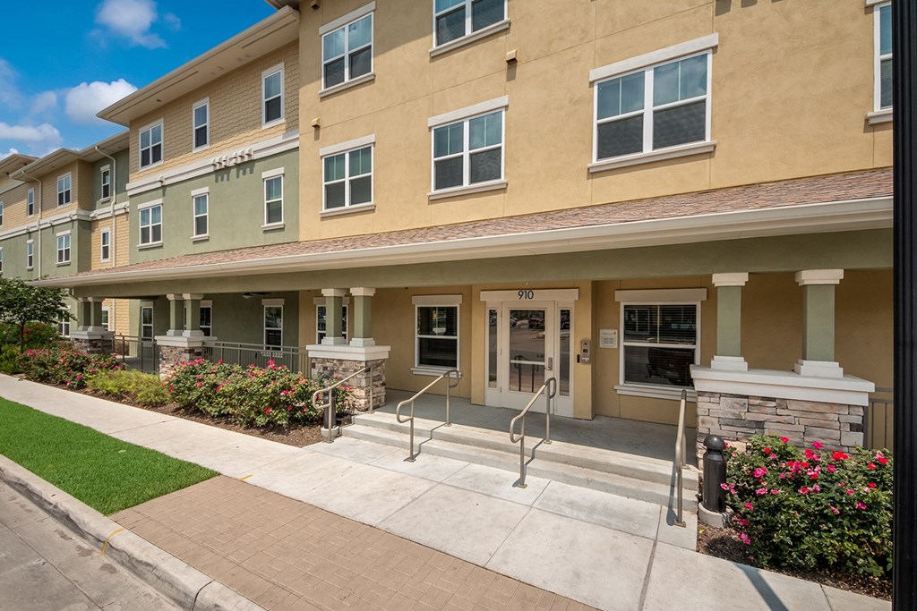 a building with stairs and a sidewalk in front of it