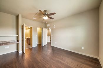 a empty living room with a ceiling fan and wood floors at Wheatley Park Senior Living San Antonio
