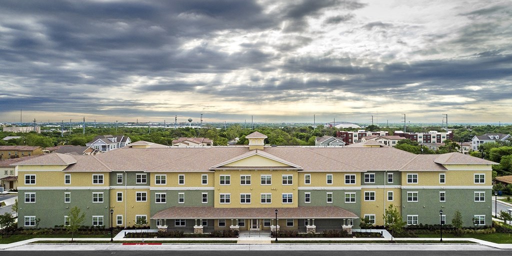 an aerial view of a row of apartment buildings with a rainbow in the sky