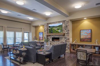 a living room with a fireplace and couches at Wheatley Senior Living San Antonio