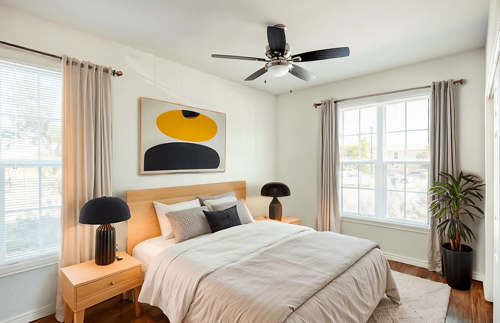 a bedroom with a bed and a ceiling fan at East Meadows apartments in San Antonio, TX