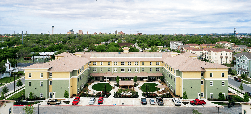an aerial view of a large building with cars parked in front of it at Wheatley Park Senior Living Apartments