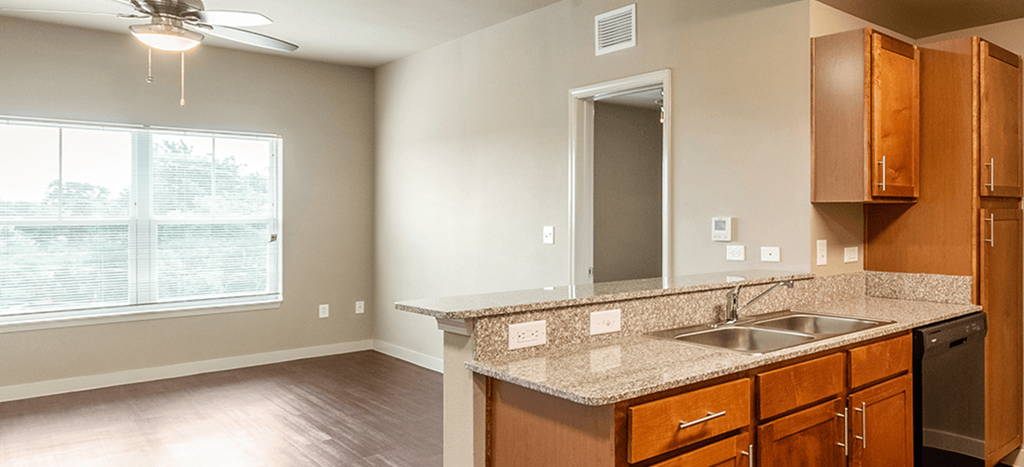an empty kitchen with a sink and a window at Wheatley Park Senior Living Apartments