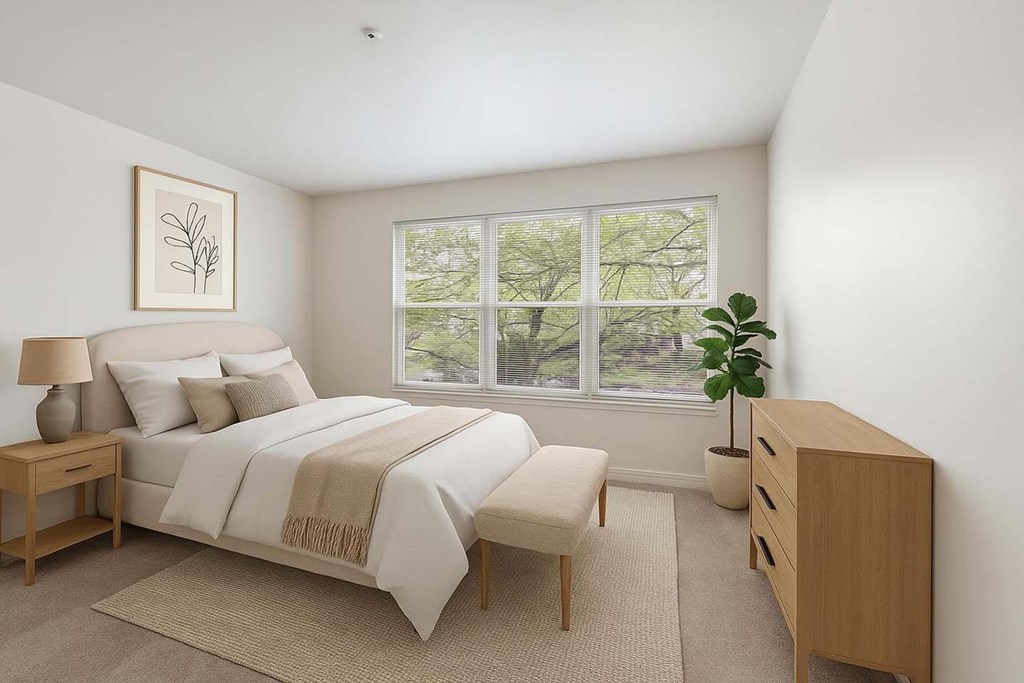 A bedroom with a bed, nightstand, and a plant.