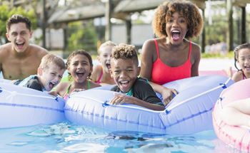 Family in swimming pool on donut floaties