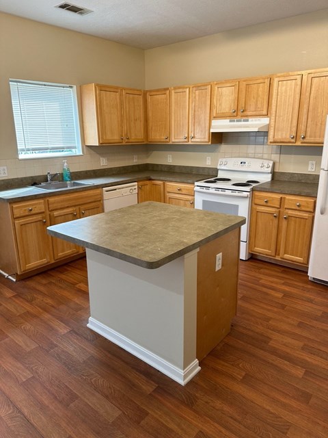 an empty kitchen with an island in the middle of it