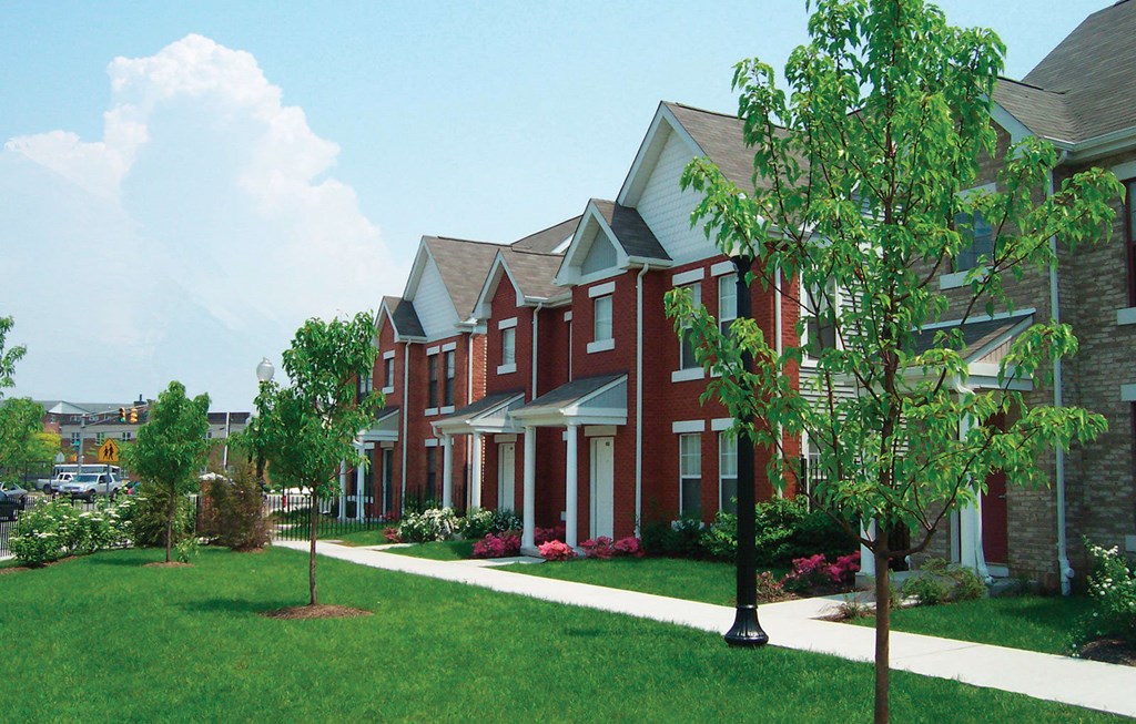 A red brick house with a white door and windows.
