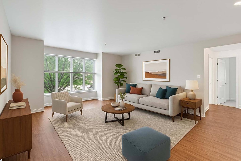 A living room with a couch, chair, and a table with a vase on it.