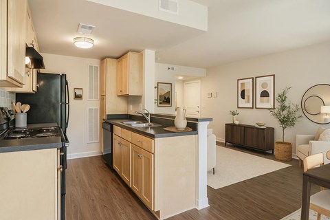 A kitchen with wooden cabinets and a black refrigerator.