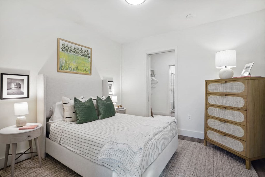 a bedroom with a bed and a dresser and a bathroom at Sinclaire on Seminary, Alexandria Virginia