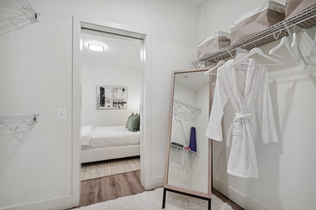 a bathroom with a mirror and a closet with robes and a bed at Sinclaire on Seminary, Virginia, 22311