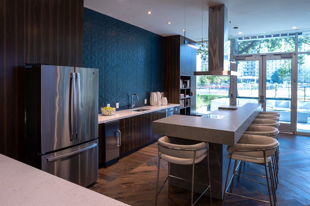 a kitchen with stainless steel appliances and a counter with bar stools at Sinclaire on Seminary, Alexandria, VA