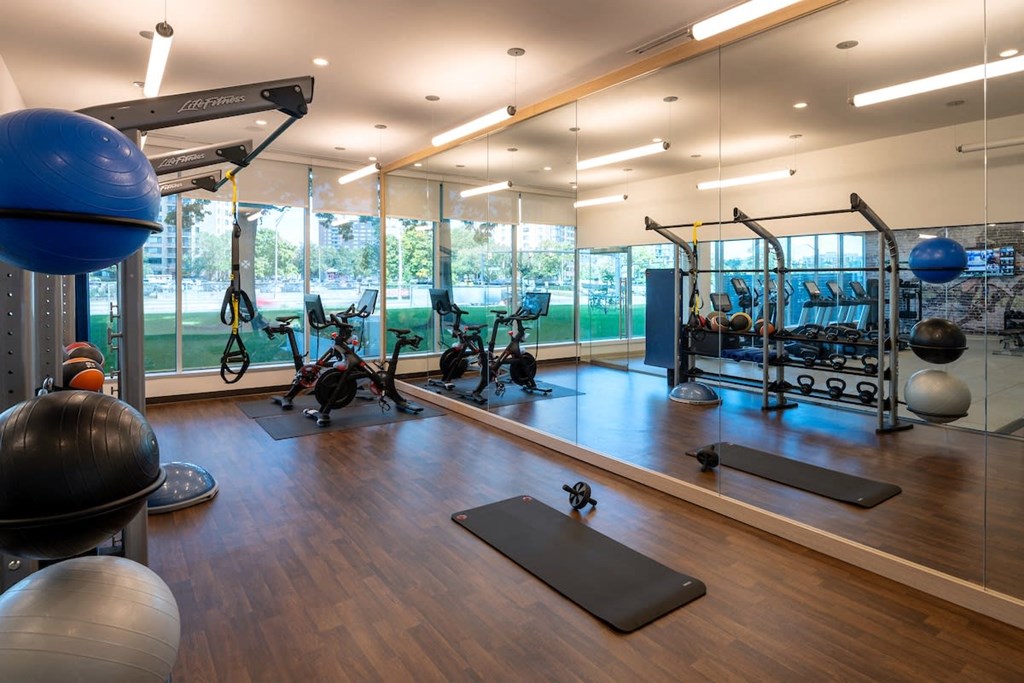 a gym with weights and other exercise equipment and a view of a tennis court at Sinclaire on Seminary, Alexandria, VA 22311