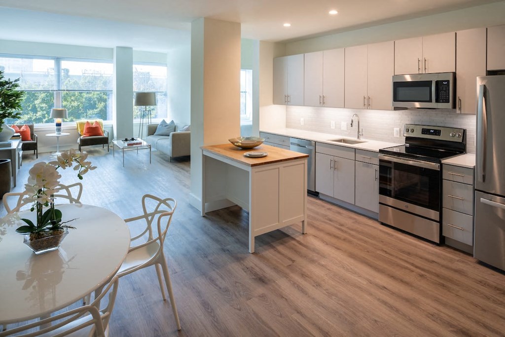 a kitchen and dining room with white cabinets and stainless steel appliances at Sinclaire on Seminary, Virginia, 22311