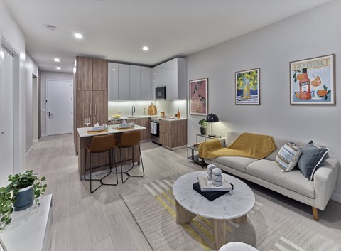 a living room and kitchen with a couch and a table