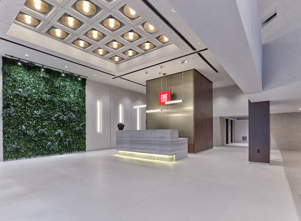 a lobby with a reception desk and a green wall