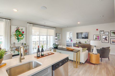 A modern kitchen with a stainless steel sink and a white countertop.