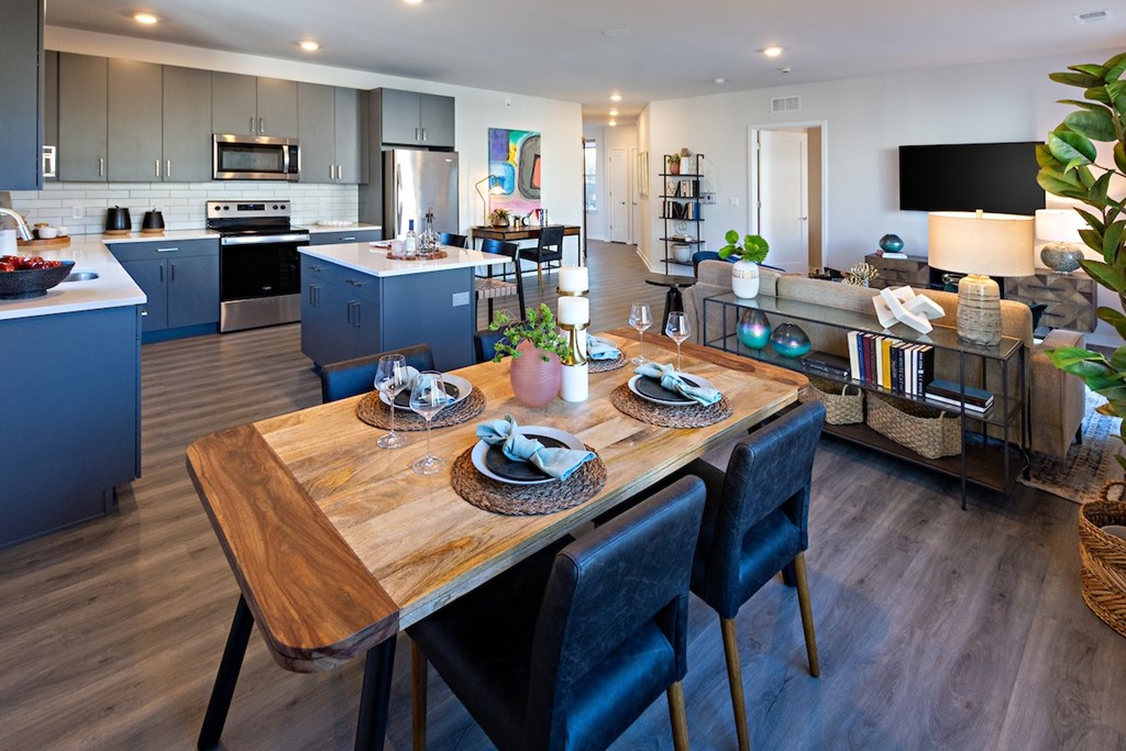 a kitchen and dining room with blue cabinets and a wooden table