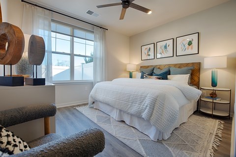 A bedroom with a large bed and a ceiling fan.