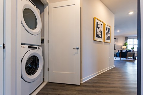 A white door with a washing machine in the left side of the door.