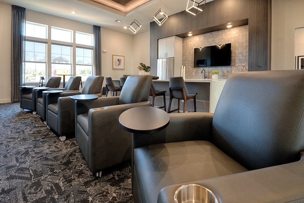 a lounge area with chairs and tables and a television