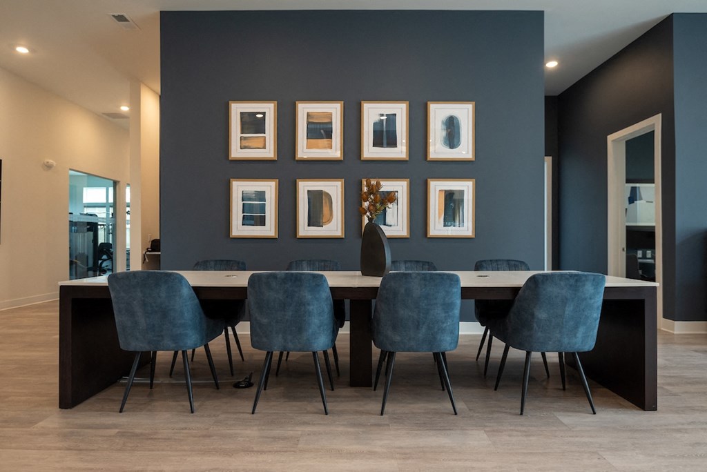 a dining room with a long table and blue chairs