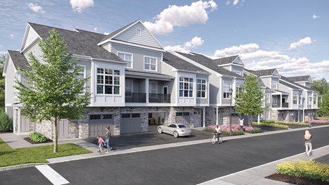 A row of houses with people walking and biking in front.