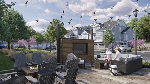 A couple is sitting on a couch on a patio with a fire pit in front of them.