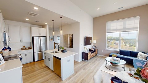 A modern kitchen with white cabinets and a wooden island.