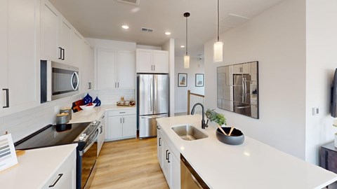 A modern kitchen with white cabinets and a large island.