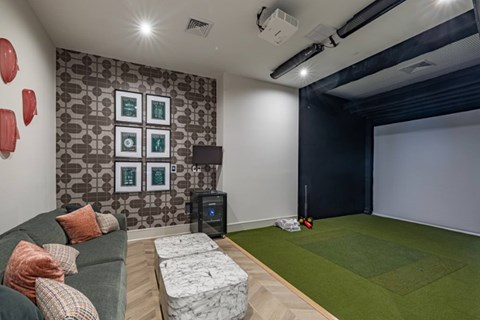 A room with a couch, a wall with pictures and a projector.