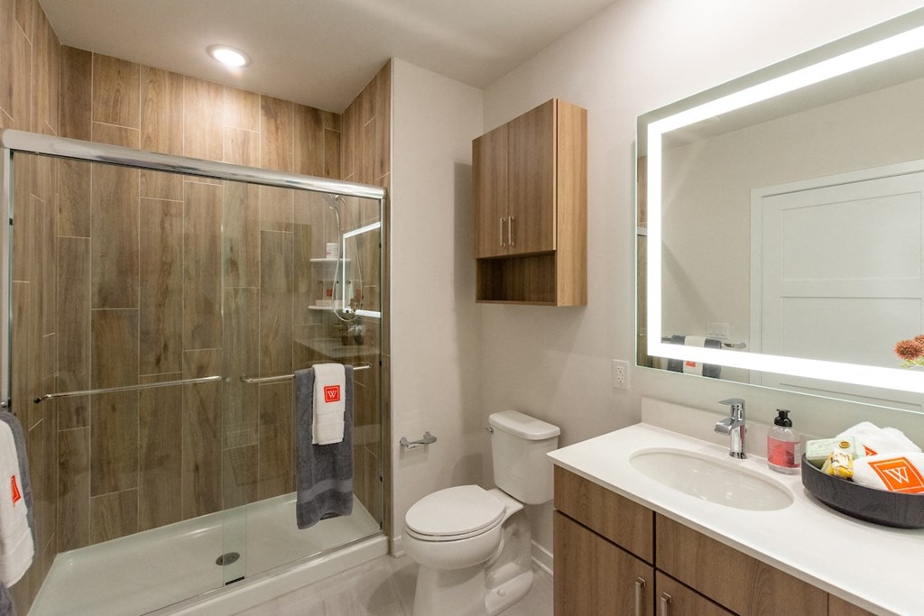 a bathroom with a shower sink and toilet in a 555 waverly unit