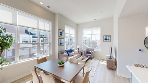 A modern living room with a dining table and chairs.