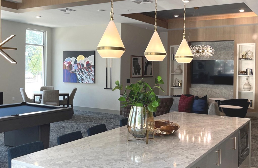 a large kitchen island with a vase of flowers on it and a pool table in the