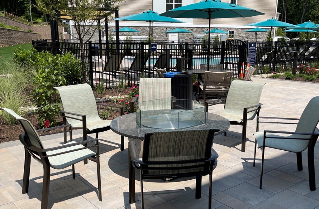 a table and chairs on a patio with umbrellas in the background